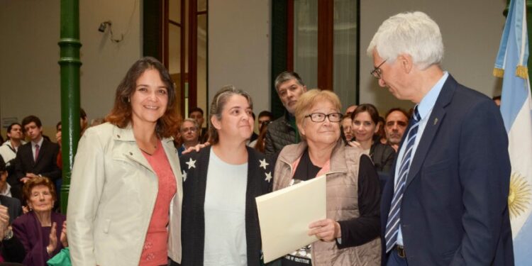 Gladis Ríos, esposa de Mancuello Bareiro, y sus hijas Claudia y Clara reciben el legajo reparado de manos del decano Marcos Actis (crédito foto: Facultad de Ingeniería)