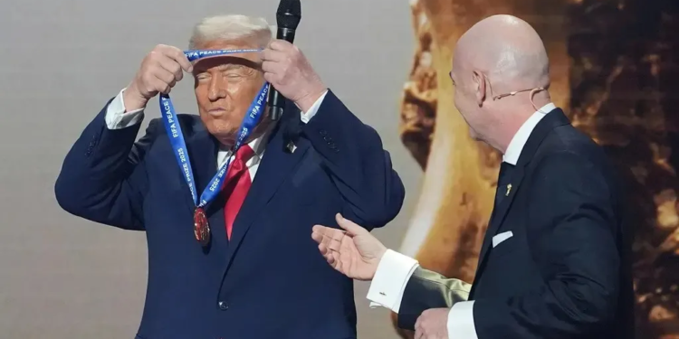 El presidente estadounidense, Donald Trump, recibe el Premio de la Paz de la FIFA de manos de Gianni Infantino, el presidente de esa Federación, durante el sorteo de la Copa Mundial, el 5 de diciembre de 2025, en Washington. (AP Foto/Evan Vucci/Cenital)